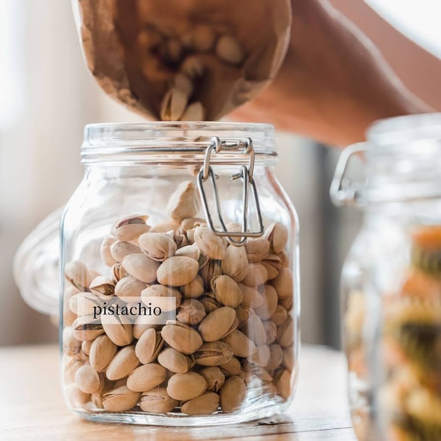 Frasco de vidrio que contiene pistachos y está identificada con una etiqueta adhesiva transparente TZe de Brother que puede ser pegada en cualquier tipo de superficie.
